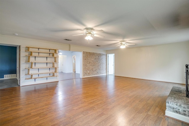 unfurnished living room with a ceiling fan, baseboards, visible vents, crown molding, and wood finished floors