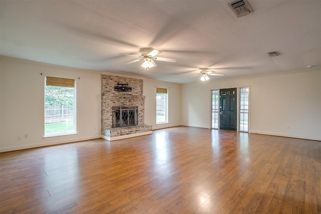 unfurnished living room with wood finished floors, visible vents, baseboards, and a ceiling fan