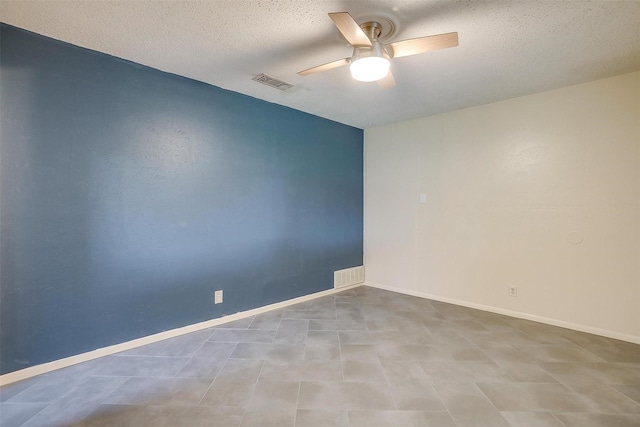empty room featuring a textured ceiling, baseboards, a ceiling fan, and visible vents