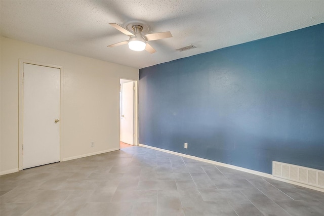 unfurnished room featuring a ceiling fan, visible vents, and a textured ceiling
