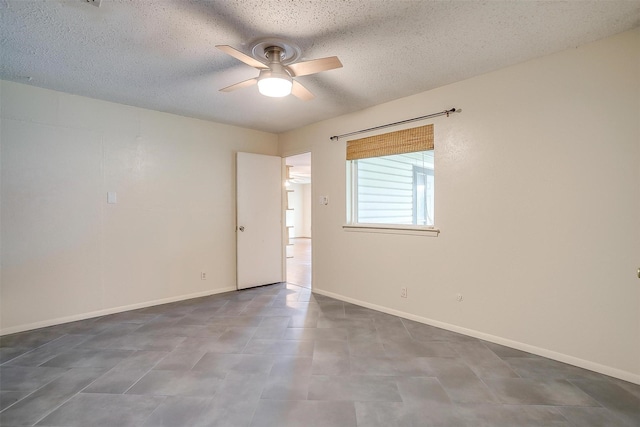 spare room featuring baseboards, ceiling fan, and a textured ceiling