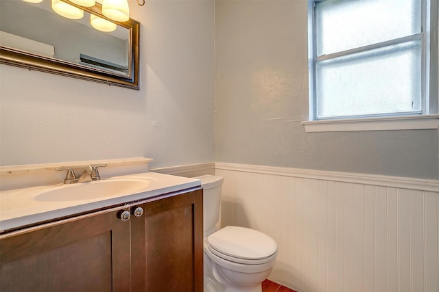 bathroom with wainscoting, vanity, and toilet