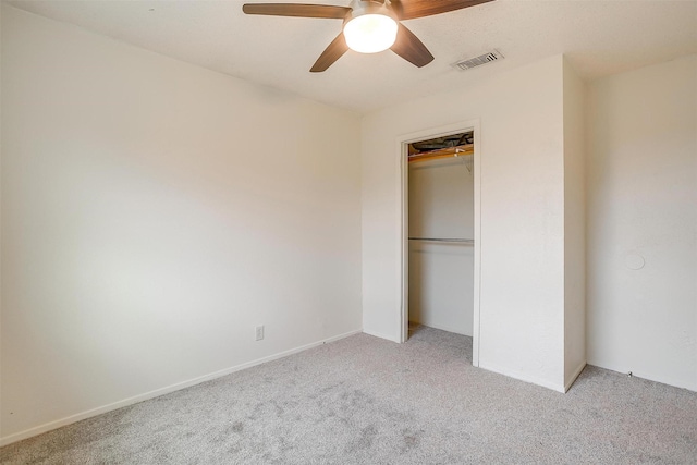 unfurnished bedroom featuring a closet, baseboards, ceiling fan, visible vents, and light carpet