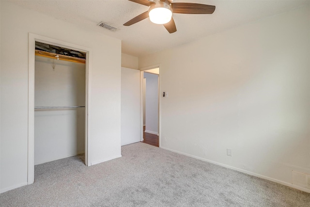unfurnished bedroom with carpet flooring, a closet, visible vents, and ceiling fan