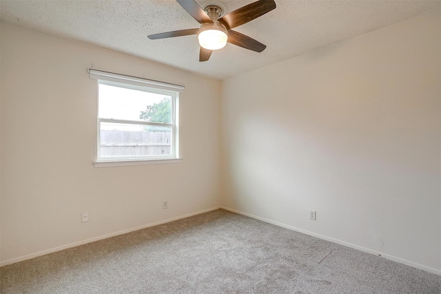 carpeted spare room with baseboards, ceiling fan, and a textured ceiling