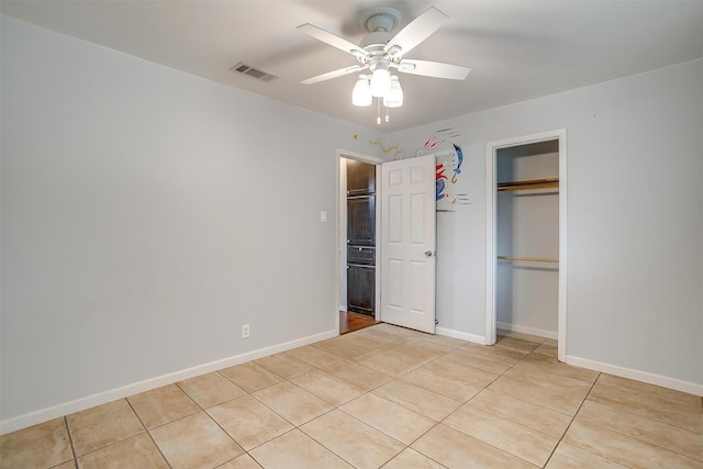 unfurnished bedroom featuring baseboards, a closet, light tile patterned floors, and visible vents