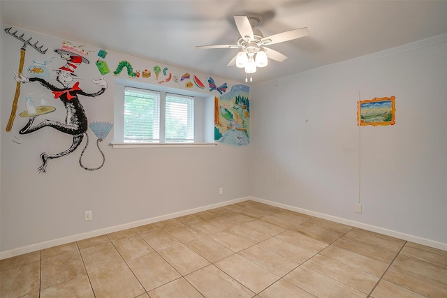 empty room featuring a ceiling fan, baseboards, and light tile patterned flooring
