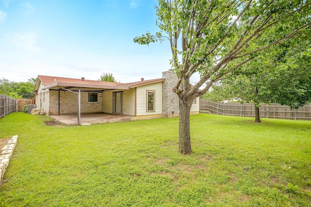 back of property featuring a lawn, a patio, and a fenced backyard
