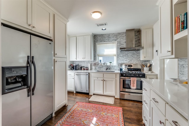 kitchen featuring visible vents, a sink, open shelves, wall chimney exhaust hood, and stainless steel appliances