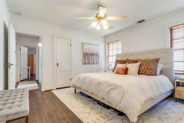 bedroom with visible vents, wood finished floors, and a ceiling fan