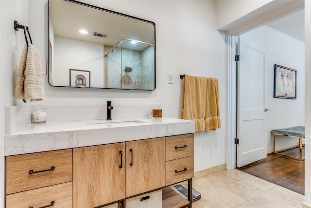full bathroom featuring tile patterned flooring, vanity, visible vents, and a walk in shower