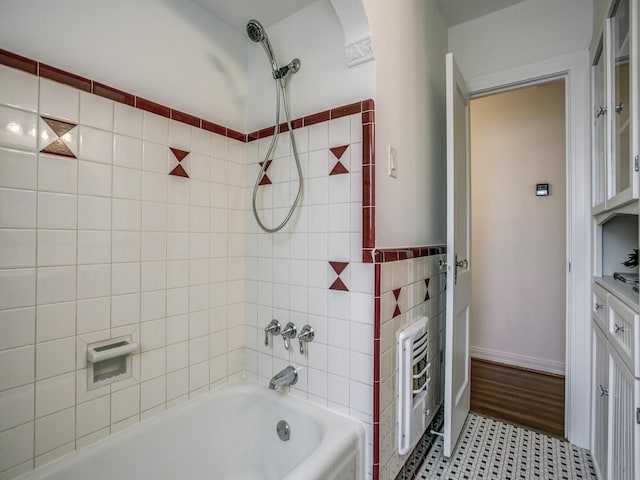 bathroom featuring heating unit, tile walls, and shower / washtub combination