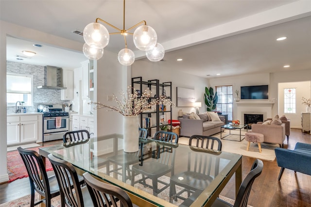 dining space featuring a fireplace, a wealth of natural light, and wood finished floors