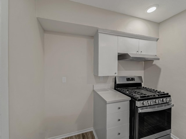 4250 Leland College Dr, Dallas, TX 75241 - kitchen with under cabinet range hood, gas stove, light countertops, white cabinets, and baseboards