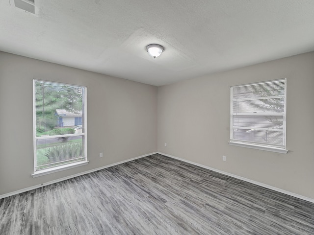 4250 Leland College Dr, Dallas, TX 75241 - empty room featuring baseboards, a textured ceiling, and wood finished floors