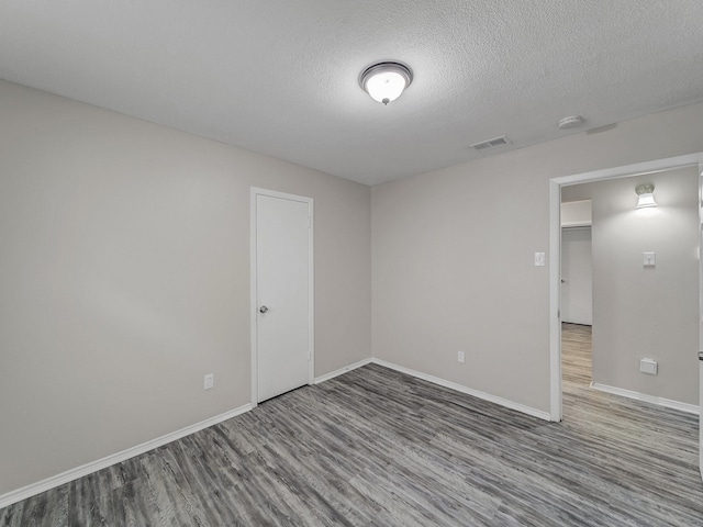 4250 Leland College Dr, Dallas, TX 75241 - empty room featuring a textured ceiling, baseboards, visible vents, and wood finished floors