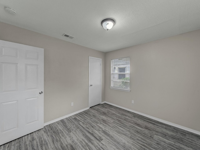 4250 Leland College Dr, Dallas, TX 75241 - spare room with baseboards, visible vents, a textured ceiling, and wood finished floors