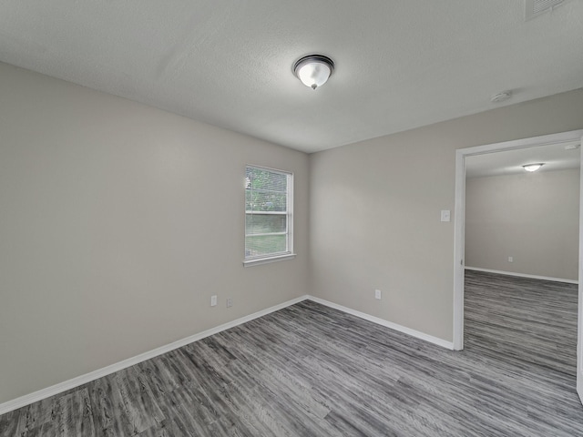 4250 Leland College Dr, Dallas, TX 75241 - empty room featuring baseboards, a textured ceiling, visible vents, and dark wood-style floors