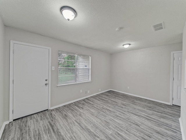 4250 Leland College Dr, Dallas, TX 75241 - entrance foyer with a textured ceiling, visible vents, wood finished floors, and baseboards