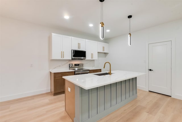 3904 De Maggio Ave, Dallas, TX 75210 - kitchen featuring a sink, stainless steel appliances, a center island with sink, light wood-style flooring, and baseboards