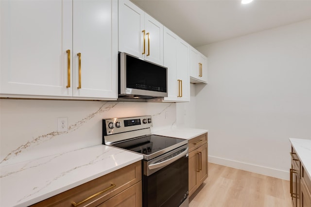 3904 De Maggio Ave, Dallas, TX 75210 - kitchen featuring stainless steel appliances, light wood-style flooring, white cabinets, light stone countertops, and baseboards
