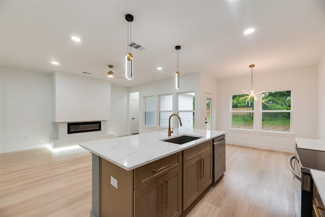 3904 De Maggio Ave, Dallas, TX 75210 - kitchen with light wood-style flooring, hanging light fixtures, a glass covered fireplace, a sink, and appliances with stainless steel finishes