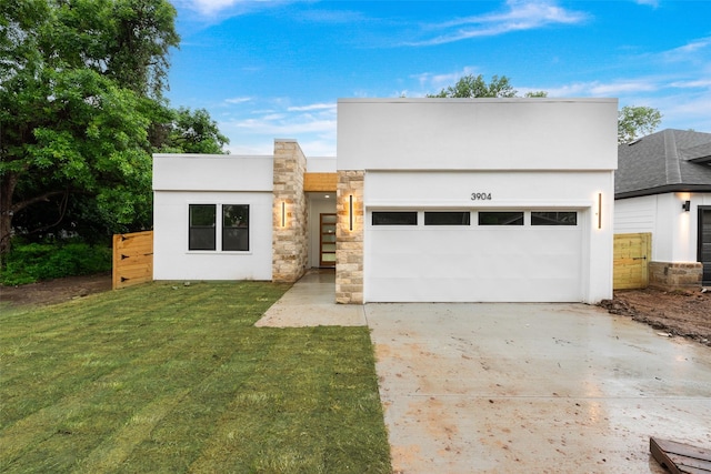 3904 De Maggio Ave, Dallas, TX 75210 - modern home with an attached garage, stone siding, concrete driveway, stucco siding, and a front lawn