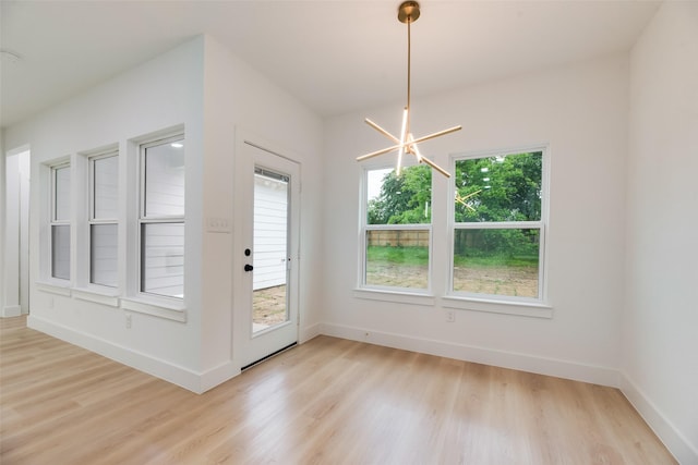 3904 De Maggio Ave, Dallas, TX 75210 - unfurnished dining area featuring baseboards, light wood-type flooring, and a notable chandelier