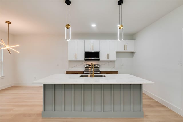 3904 De Maggio Ave, Dallas, TX 75210 - kitchen featuring stainless steel appliances, light stone counters, a kitchen island with sink, white cabinets, and baseboards