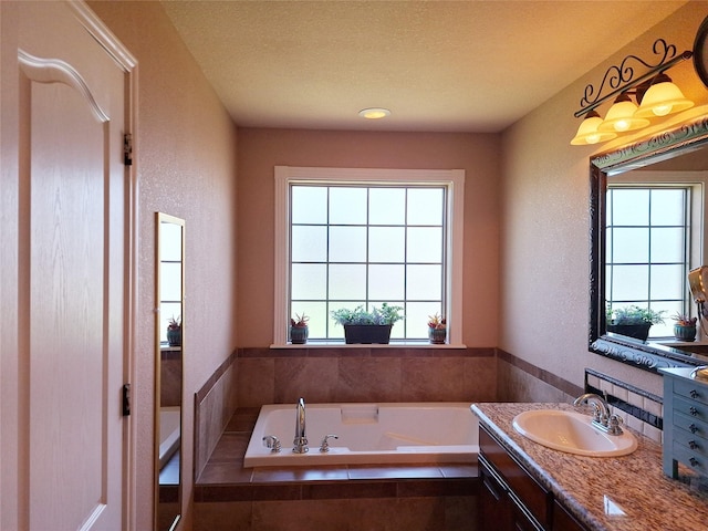 334 Miss Ellie Ln, Abilene, TX 79602 - bathroom featuring a garden tub, a wealth of natural light, vanity, and a textured wall
