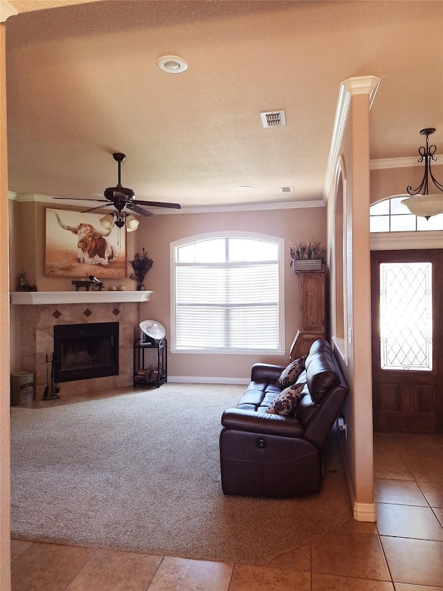 334 Miss Ellie Ln, Abilene, TX 79602 - living room featuring a ceiling fan, visible vents, tile patterned flooring, crown molding, and carpet floors