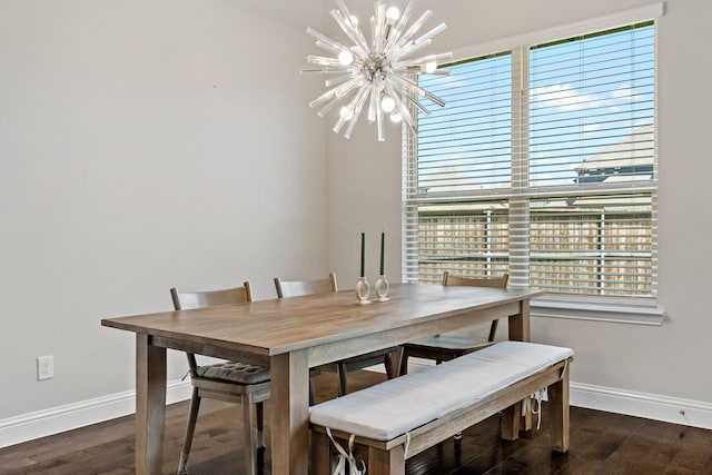 dining room with baseboards, a notable chandelier, and wood finished floors