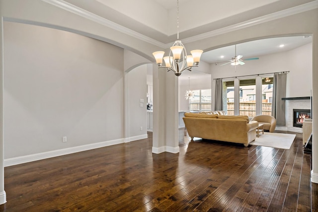 living room featuring recessed lighting, a glass covered fireplace, wood-type flooring, ceiling fan with notable chandelier, and arched walkways
