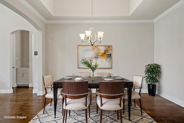 dining room featuring arched walkways, a notable chandelier, dark wood finished floors, and baseboards