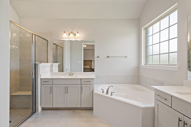 bathroom with a sink, a stall shower, tile patterned flooring, two vanities, and a garden tub