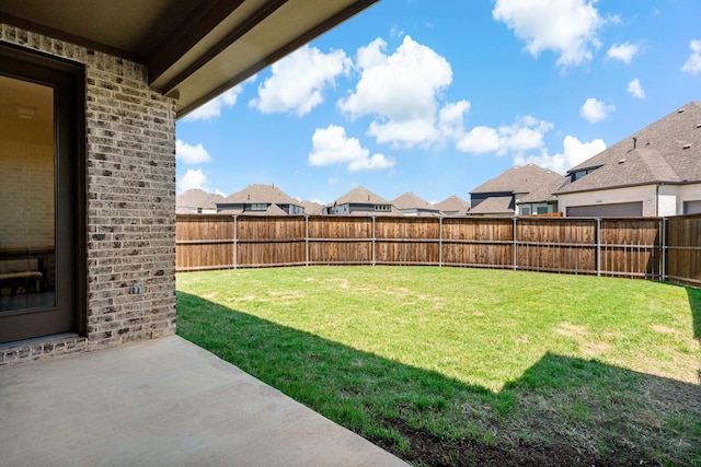 view of yard featuring a fenced backyard, a patio, and a residential view