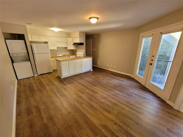 9815 Walnut St Unit 304, Dallas, TX 75243 - kitchen featuring under cabinet range hood, stacked washing maching and dryer, white appliances, and dark wood-type flooring