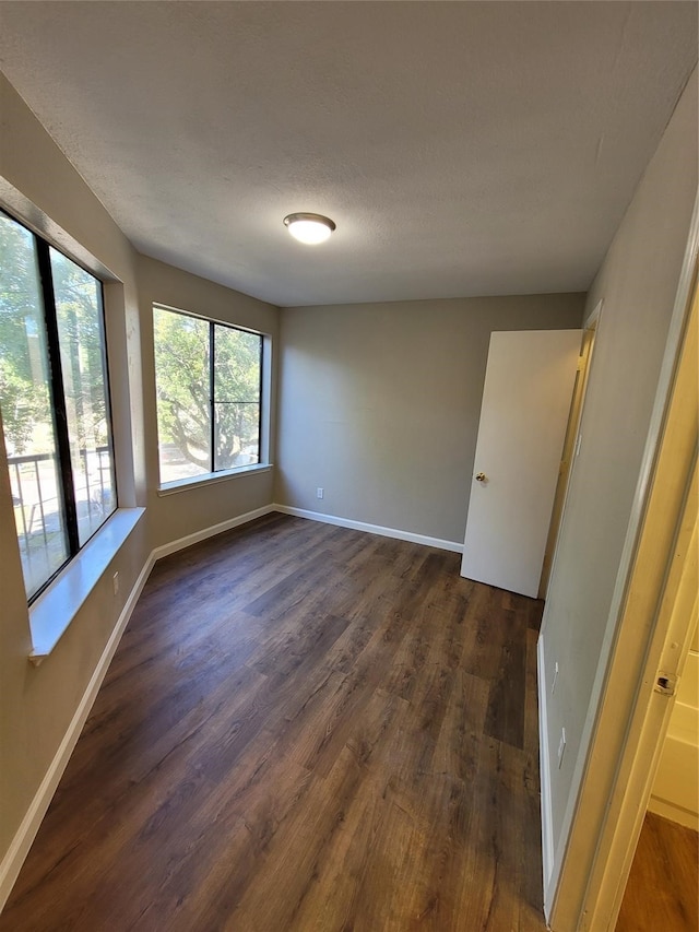 9815 Walnut St Unit 304, Dallas, TX 75243 - empty room with baseboards and dark wood-style flooring