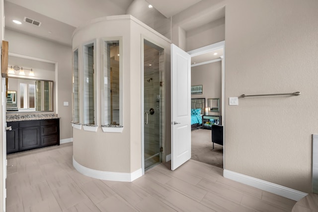 full bath featuring a shower stall, connected bathroom, vanity, baseboards, and recessed lighting