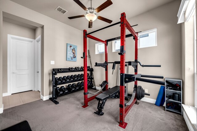 exercise room with a ceiling fan, carpet floors, and baseboards