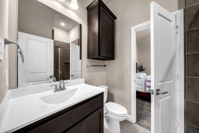 bathroom featuring toilet, vanity, tile patterned flooring, and ensuite bath