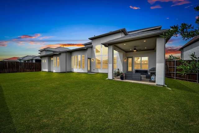 back of property with ceiling fan, stucco siding, a patio area, and outdoor lounge area