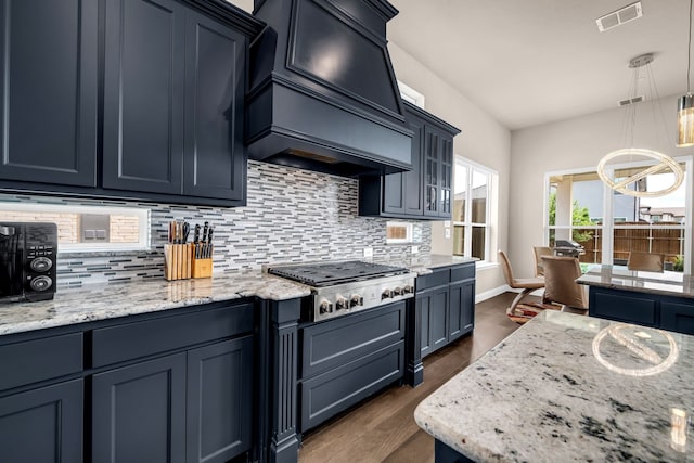 kitchen featuring stainless steel gas cooktop, decorative backsplash, premium range hood, and dark wood-style floors