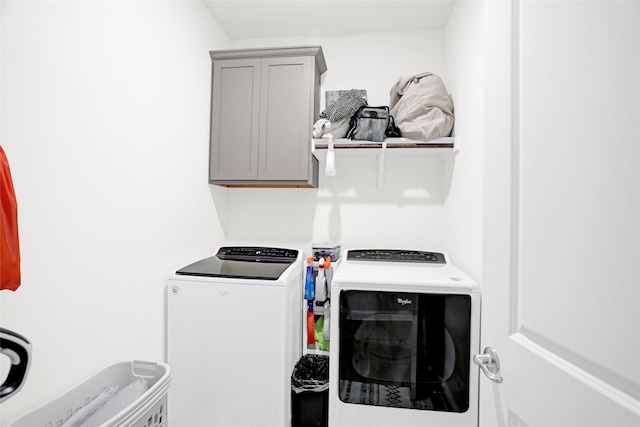 clothes washing area featuring cabinet space and washing machine and dryer