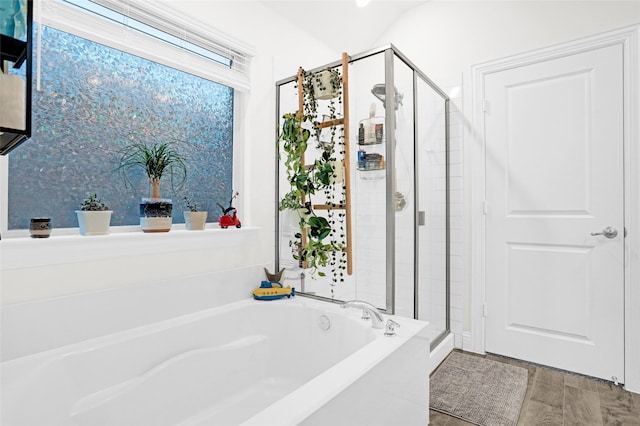 bathroom with a shower stall and a bath