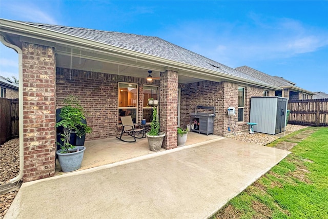 view of patio with a fenced backyard and a storage unit