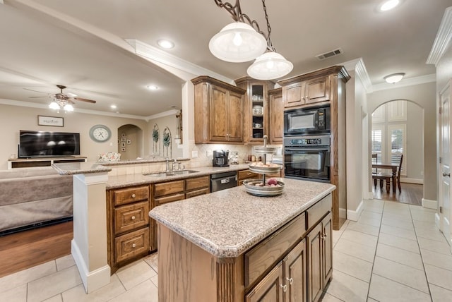 kitchen featuring brown cabinetry, light tile patterned floors, visible vents, arched walkways, and black appliances