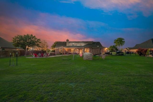yard at dusk with a patio area and fence