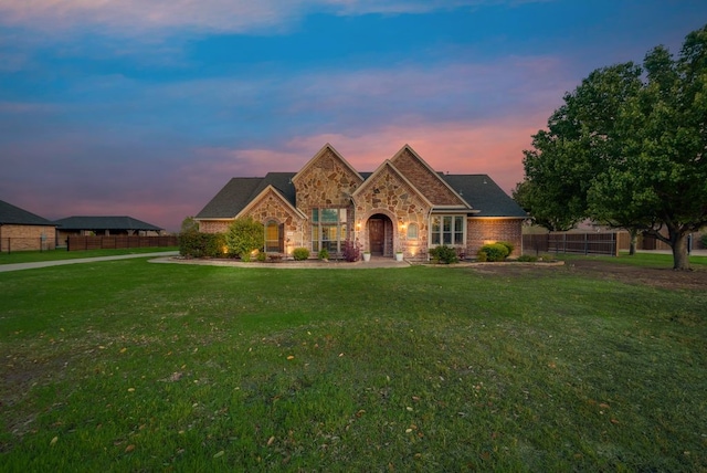 view of front of property featuring a front lawn, fence, and stone siding