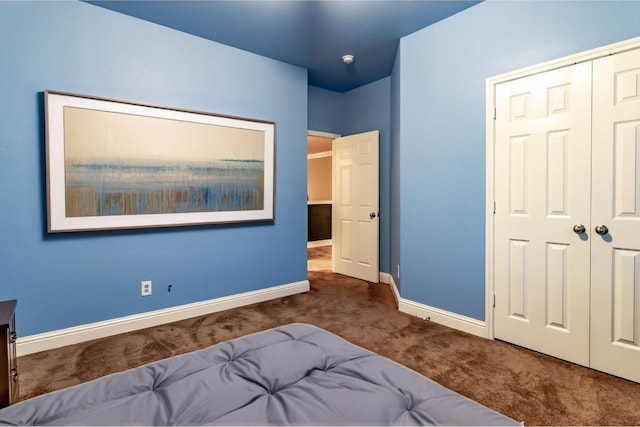 carpeted bedroom with a closet and baseboards